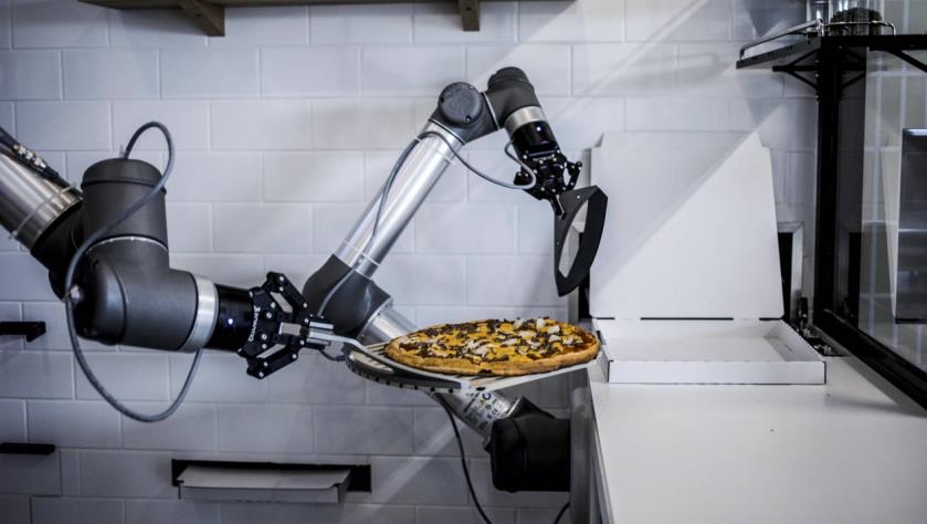 Bras articulé du robot déplace une pizza