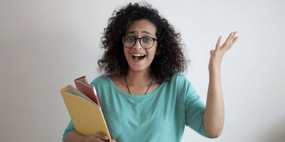 Une femme tiens une pile de dossiers de presse dans ses bras